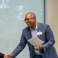 President Mantella shaking hands on stage with Kala Gibson